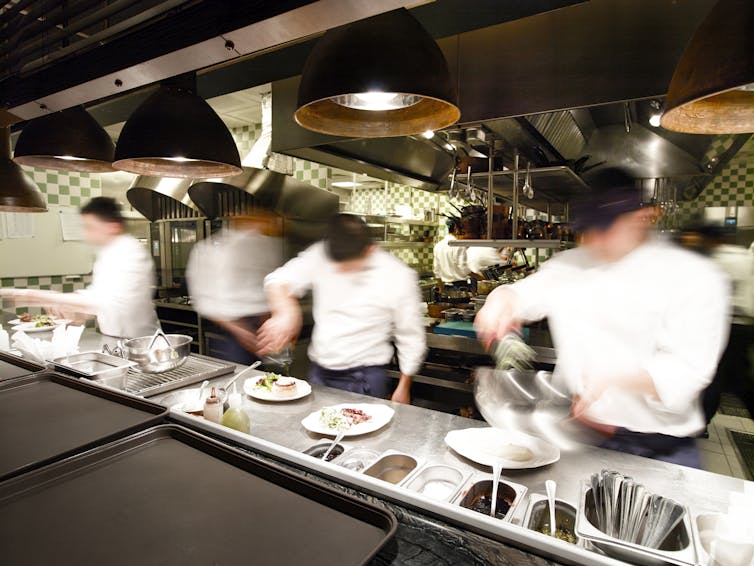 bluured image of chefs in a restaurant kichen