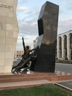 A monument shows two people pushing a structure.