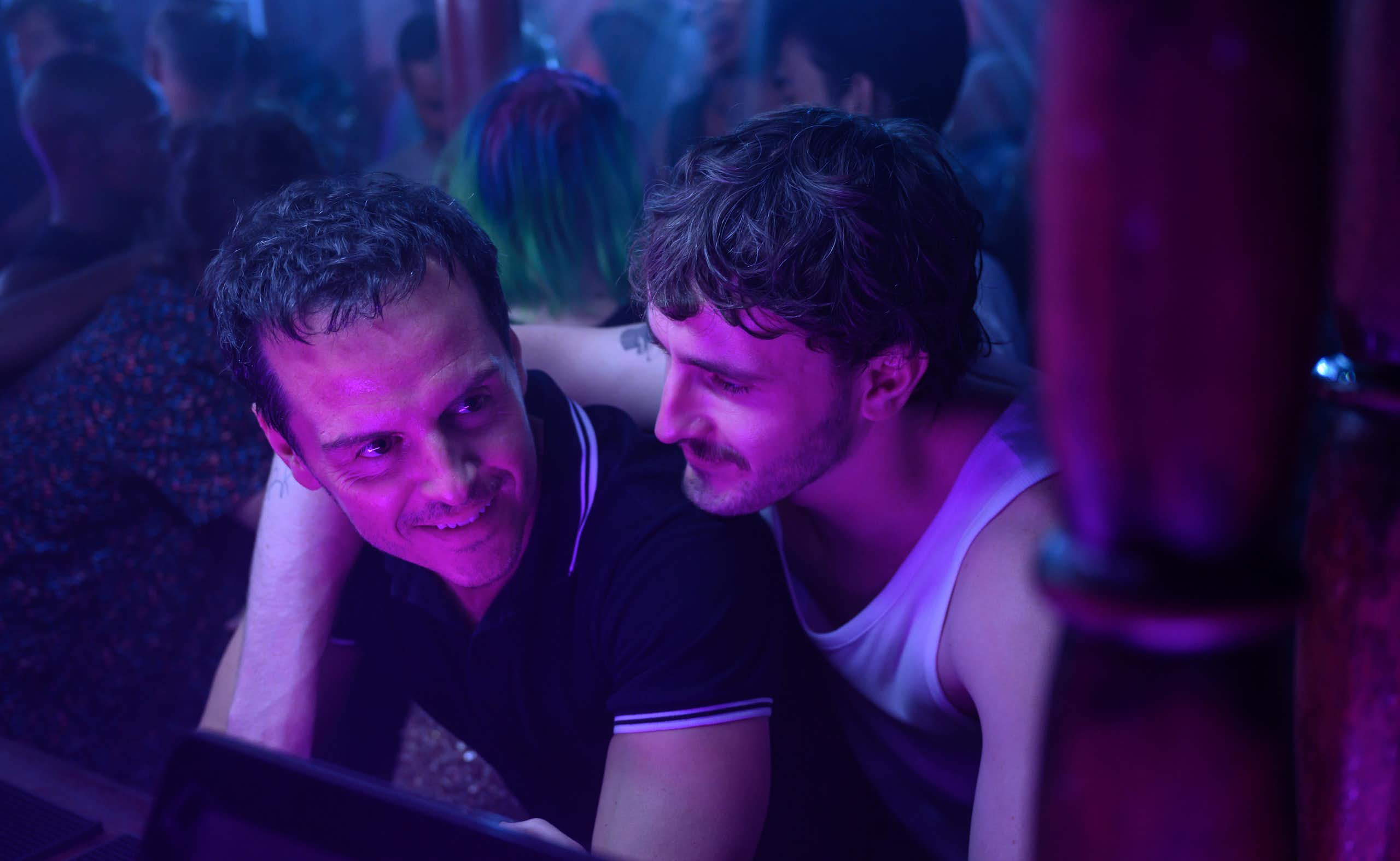 Two men embrace at a club