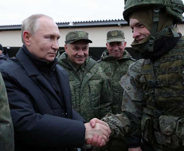 Poutine et Choïgou saluent des militaires en tenue de camouflage
