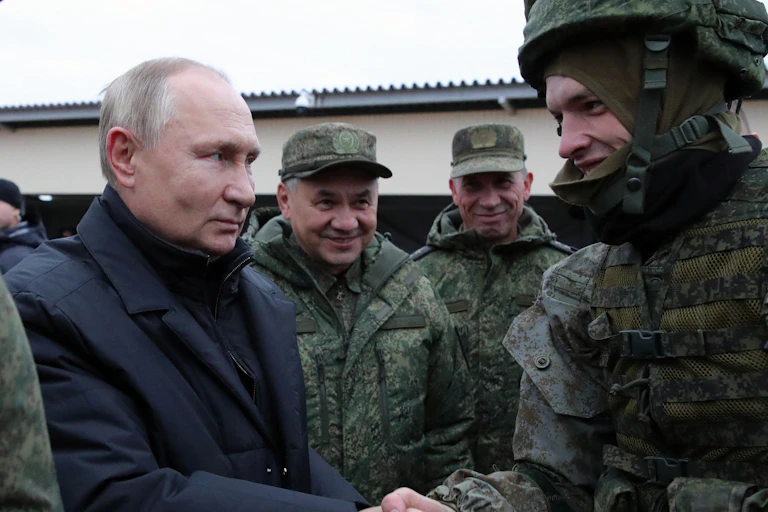Poutine et Choïgou saluent des militaires en tenue de camouflage