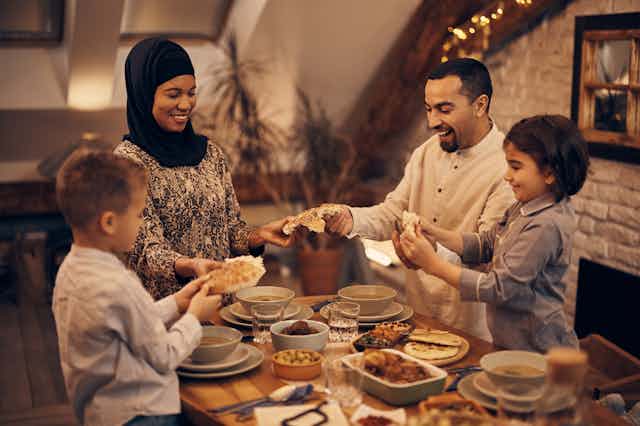 A Muslim family breaking fast with pitta bread and other foods