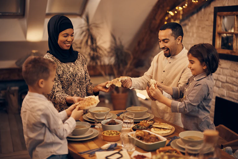 A Muslim family breaking fast with pitta bread and other foods