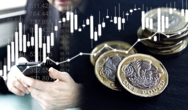 A close up of a pair of hands holding a mobile phone with pound coins superimposed onto the foreground.