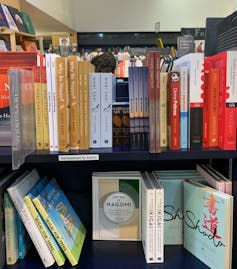 Two rows of books displayed spine-out in a store.