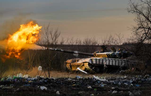 A fire ball erupts as a tank fires a shell