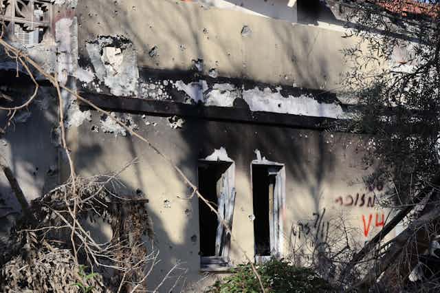the exterior of a dwelling showing smoke and weapon damage