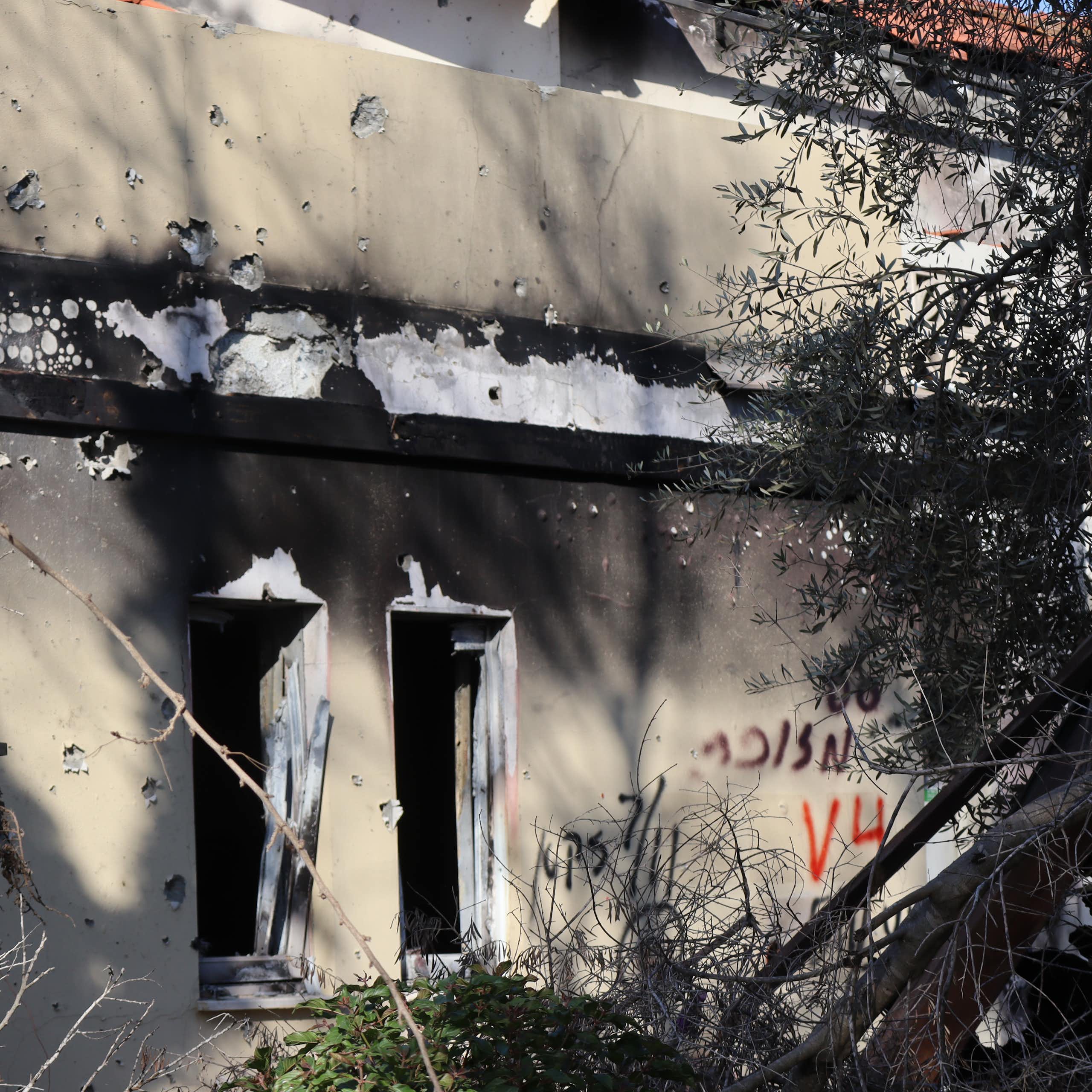 the exterior of a dwelling showing smoke and weapon damage