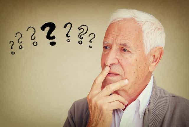 Older man with question marks next to his head