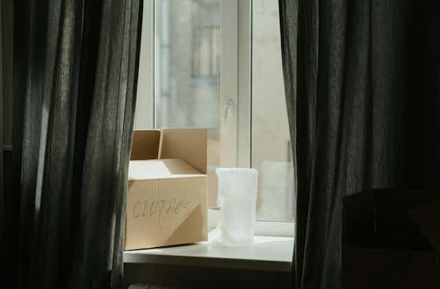 A box marked clothes sits on a window sill.