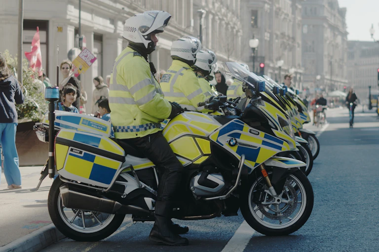 View from the side of a row of Met Police officers lined up on police motorbikes