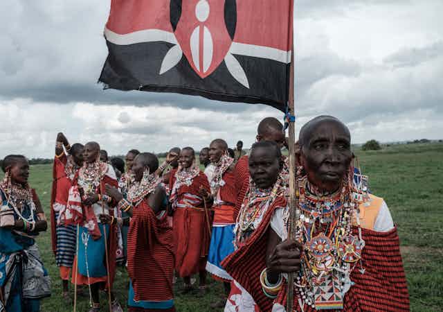 A group of Maasai women, with one holding a Kenyan flag