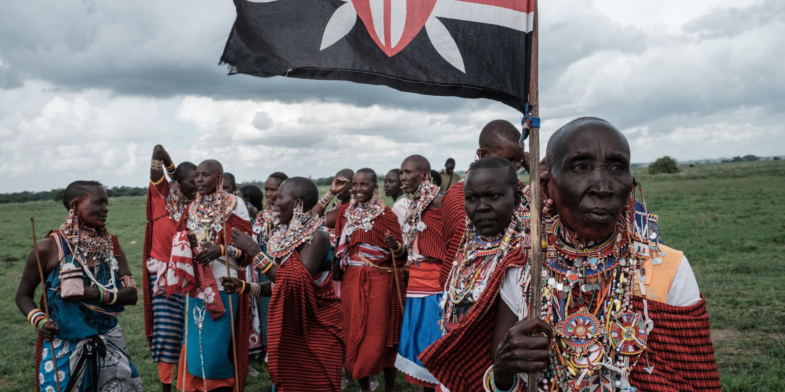 A group of Maasai women, with one holding a Kenyan flag