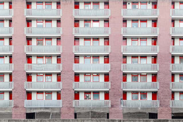A council housing block with red and pale red detailing.