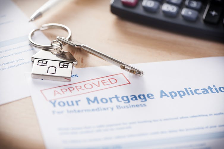 An approved mortgage loan application with a house-shaped keyring.