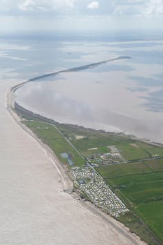 A spit of land extending into an estuary.