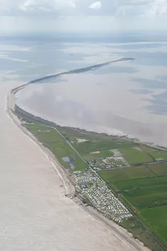 A spit of land extending into an estuary.