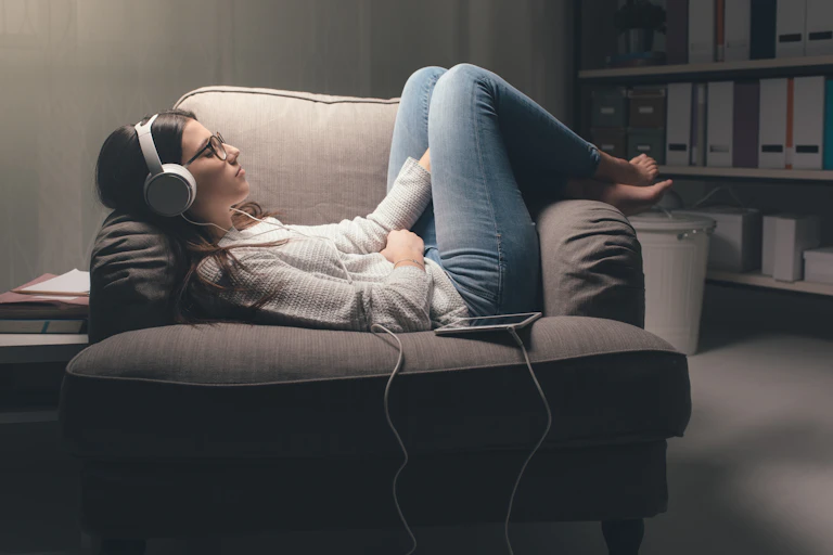 Woman with noise-cancelling headphones sits on a chair