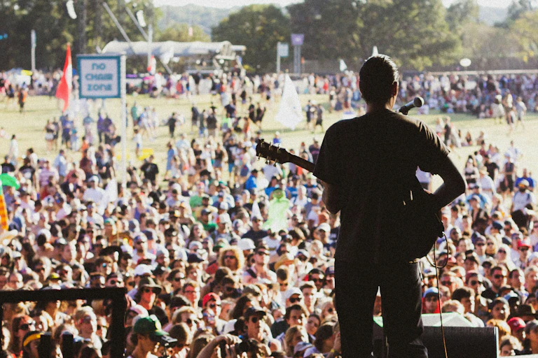 A man plays guitar at a festival