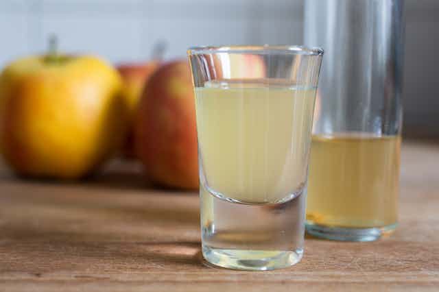 shot glasses of cloudy apple drink