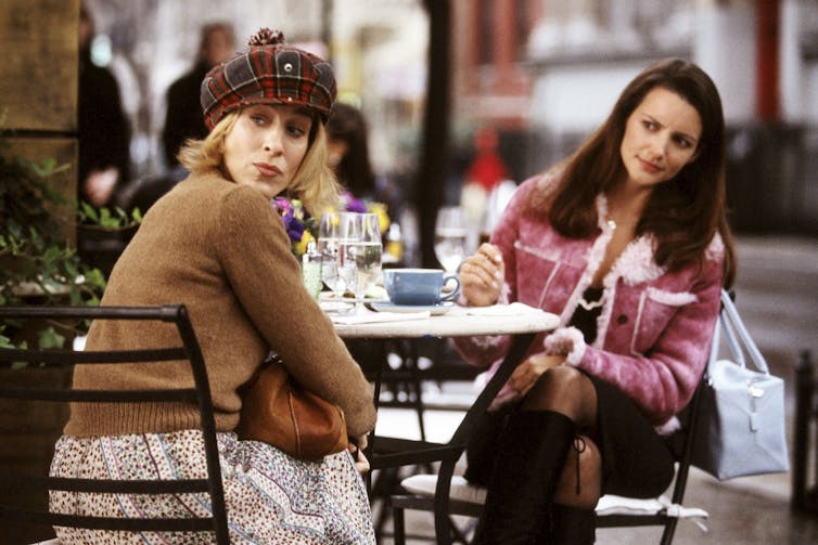 Two women sitting at an outdoor cafe.