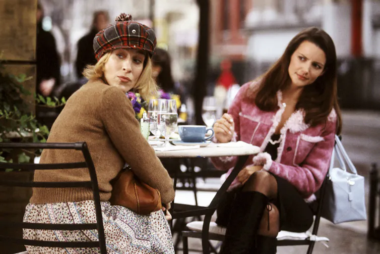 Two women sitting at an outdoor cafe.
