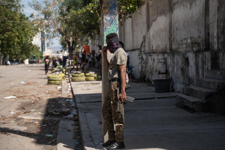 Un policía enmascarado armado al borde de una carretera en Haití.