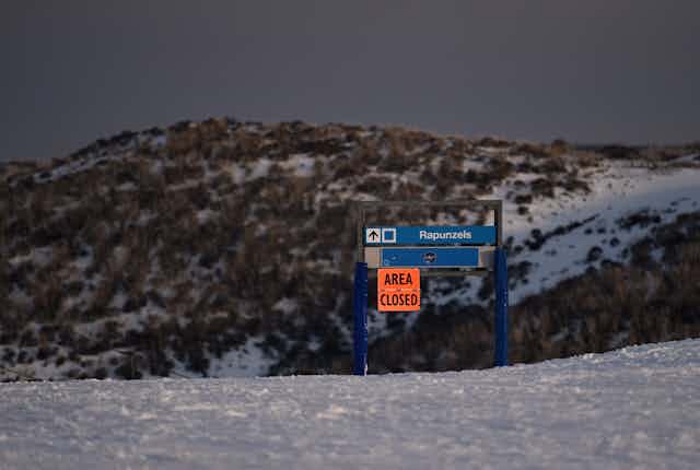 A sign announces a ski run is closed