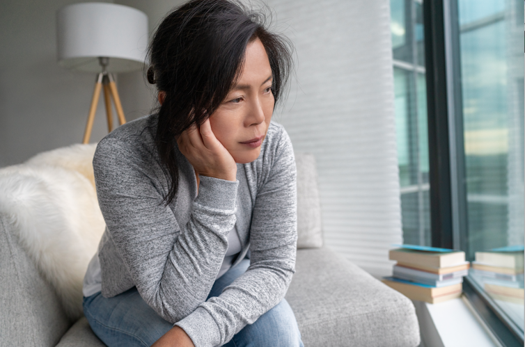 Woman sits on chair, looking deflated