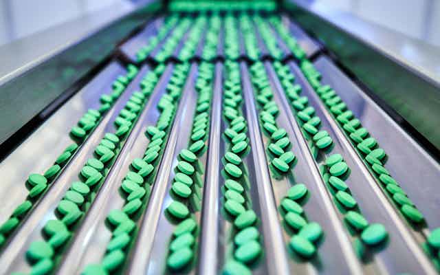 A conveyor belt of green pills 
