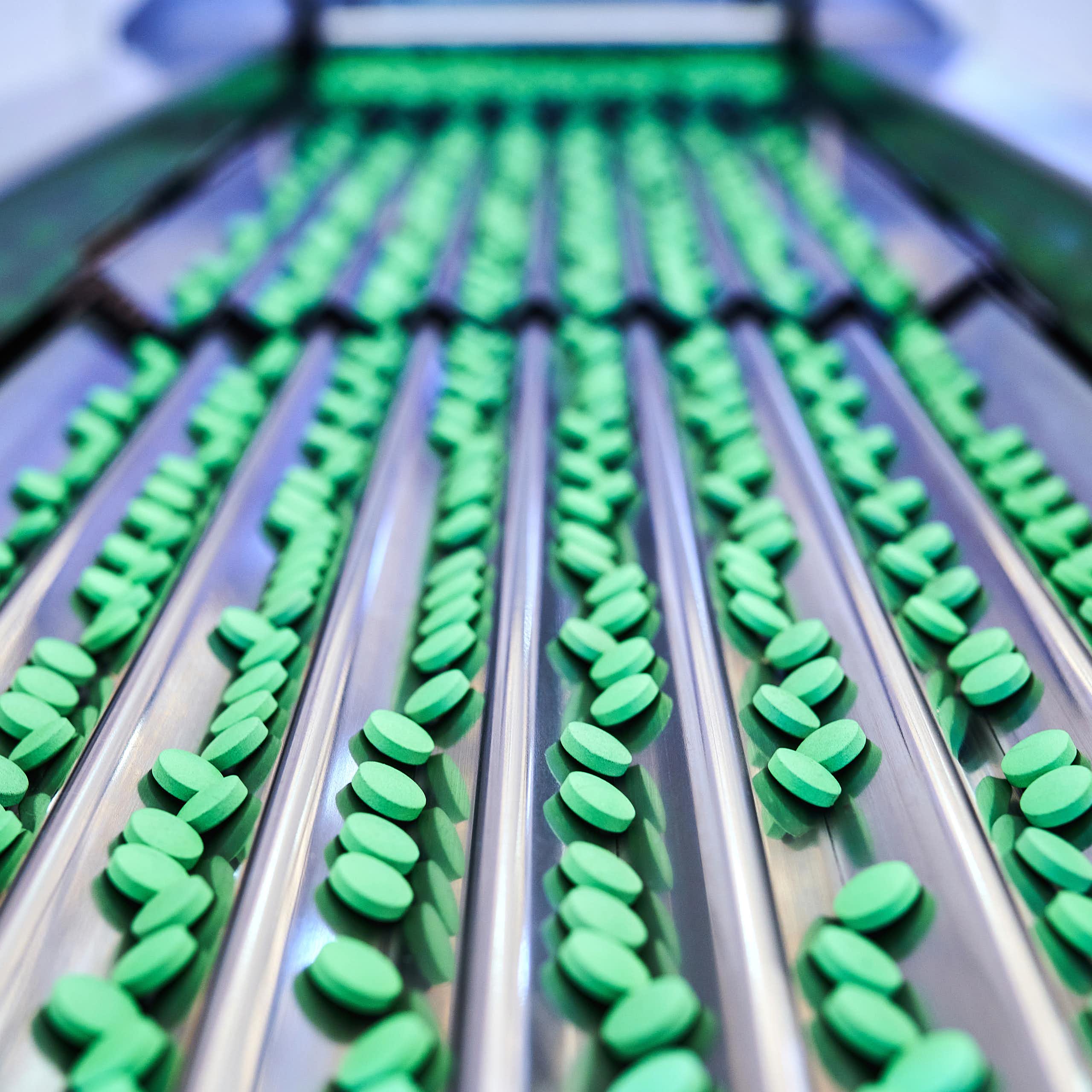 A conveyor belt of green pills 