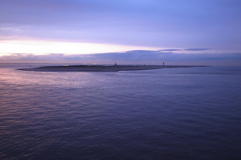 A maritime view of an almost submerged strip of land.