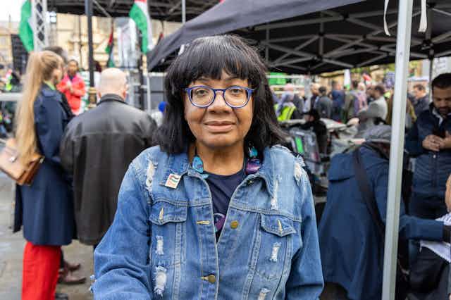 Diane Abbott looking directly at the camera while her picture is taken at an outdoor event. 