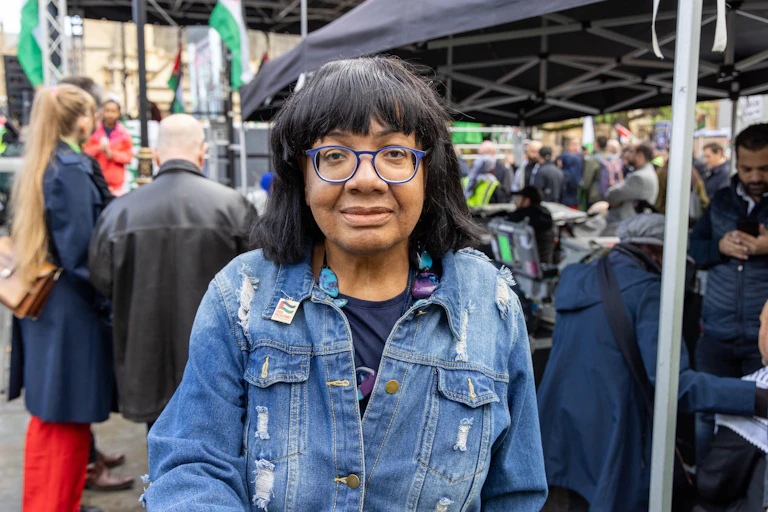 Diane Abbott looking directly at the camera while her picture is taken at an outdoor event.