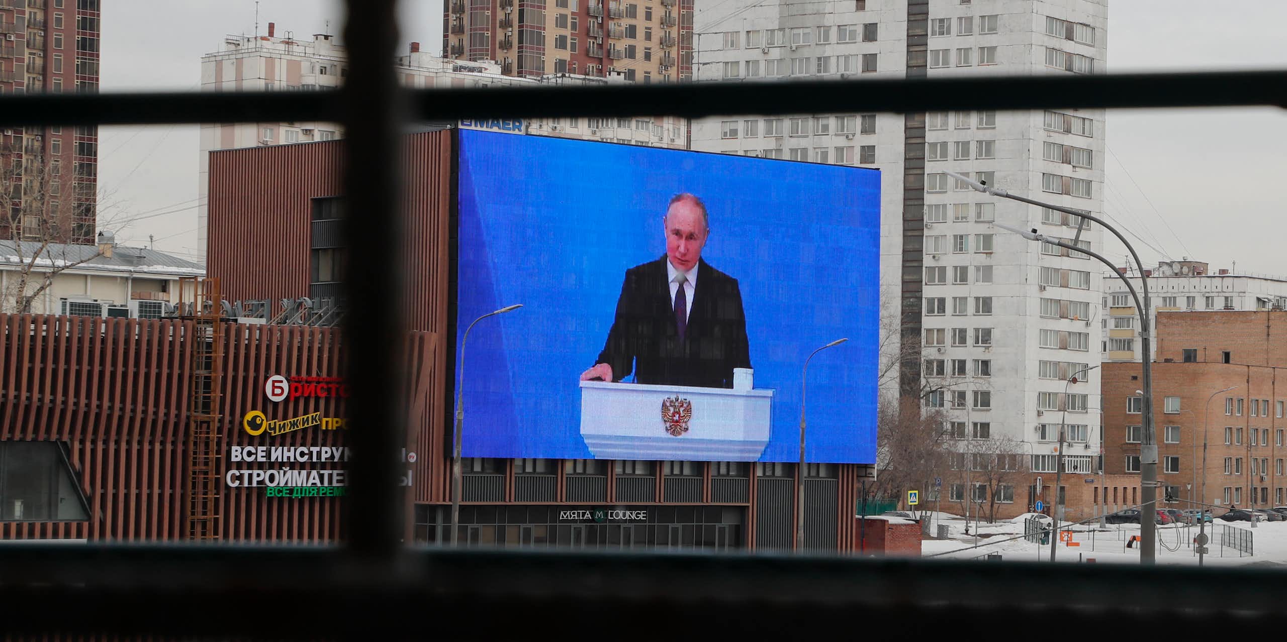 A big screen in a street showing Vladimir Russia. 