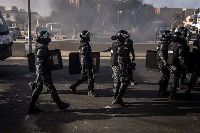 Des policiers en tenue anti-émeute en patrouille.