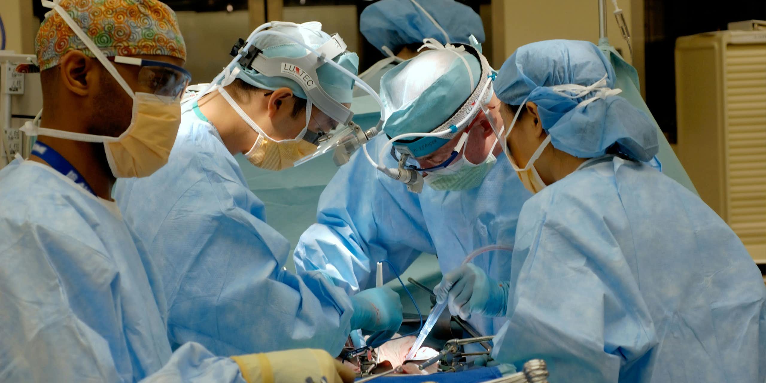 Une salle d'opération, où plusieurs professionnels de santé opèrent un patient