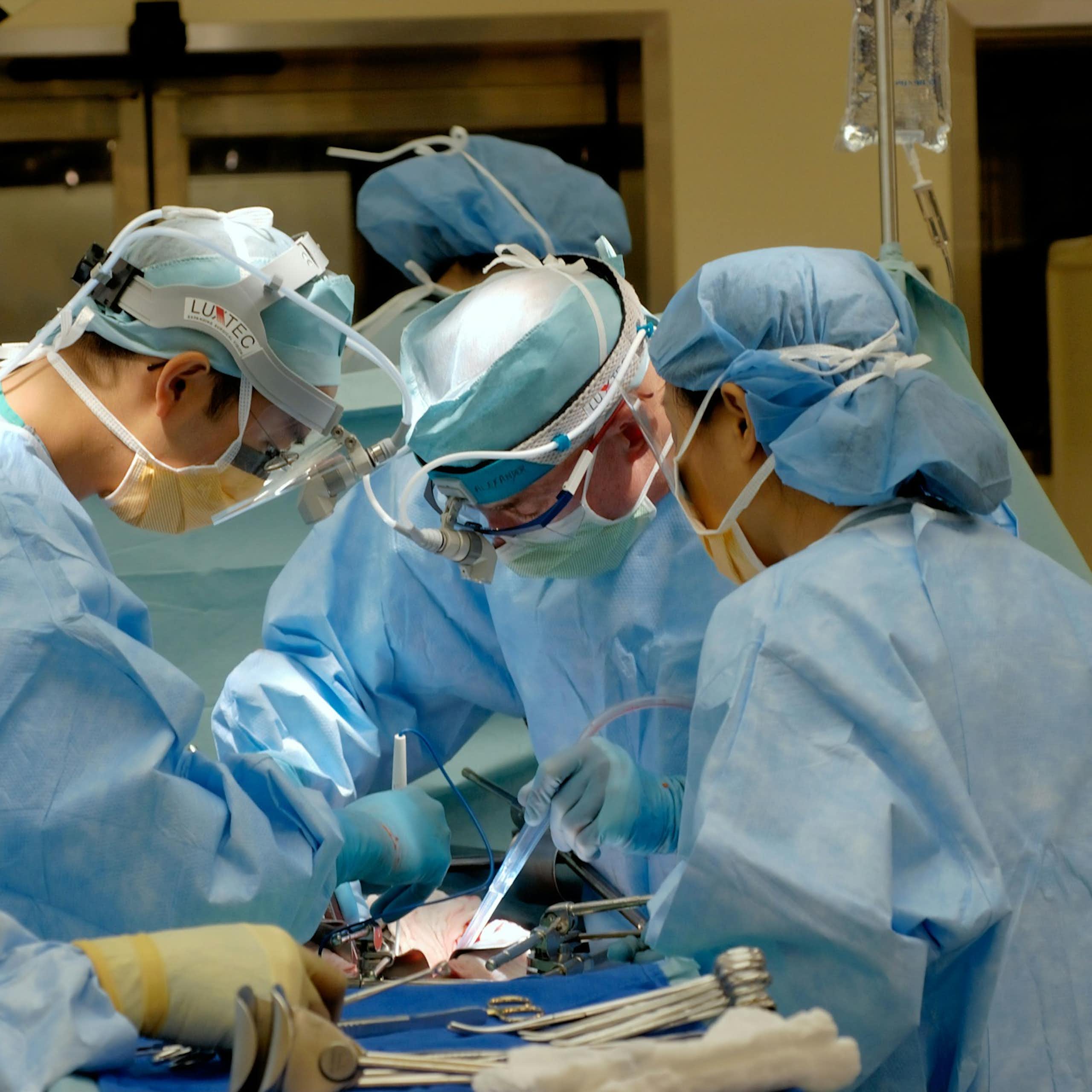 Une salle d'opération, où plusieurs professionnels de santé opèrent un patient