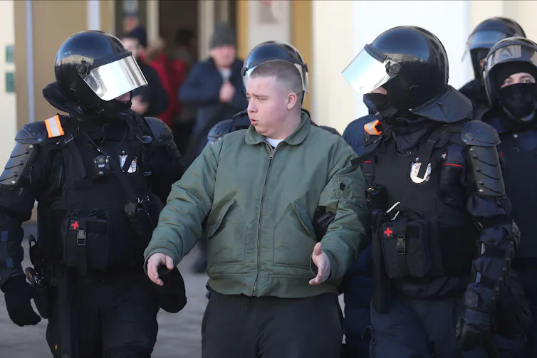 Russian police in riot gear detain a protester, March 2022.