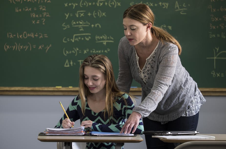 Professeur aidant une lycéenne à résoudre un problème de maths