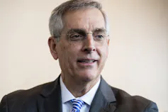 A close-up of a man in a suit and tie.