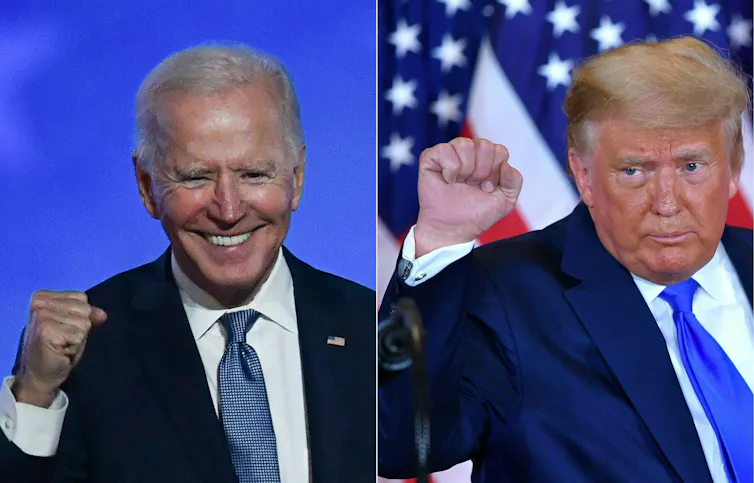 Two men in blue jackets, white shirts and ties, pumping their fists.