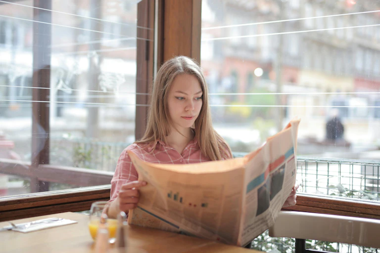 A woman reads the paper in a cafe.