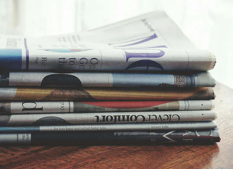 A stack of newspapers sits on a table