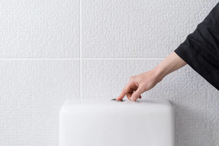 Finger pressing toilet flush