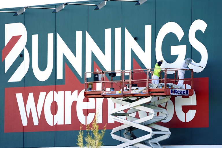 Workers repaint a Bunnings Warehouse sign