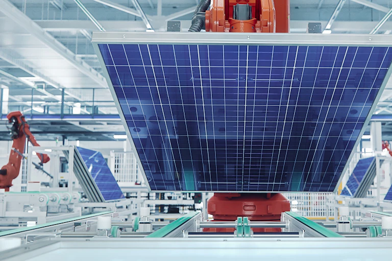 Orange Industrial Robot Arm Grabs and Moves Solar Panels on Conveyor