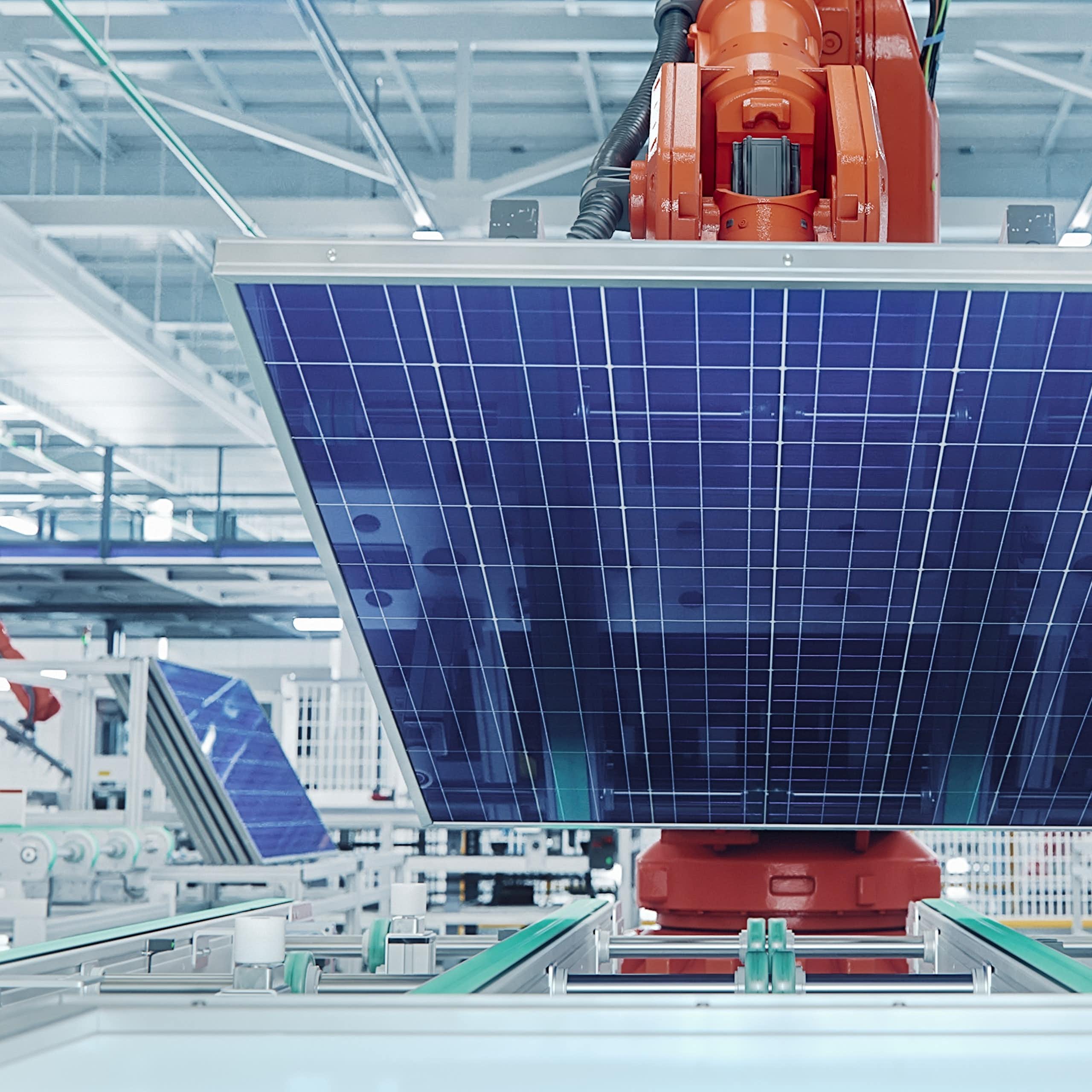 Orange Industrial Robot Arm Grabs and Moves Solar Panels on Conveyor