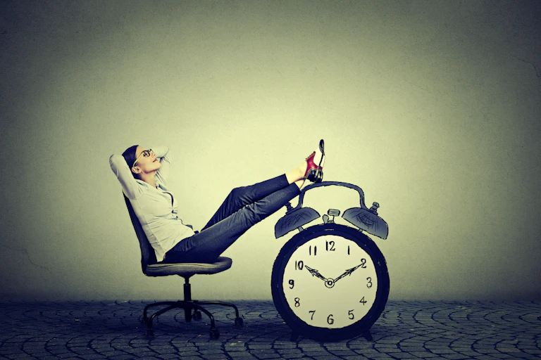 Woman relaxes on chair with feet up on a large clock.
