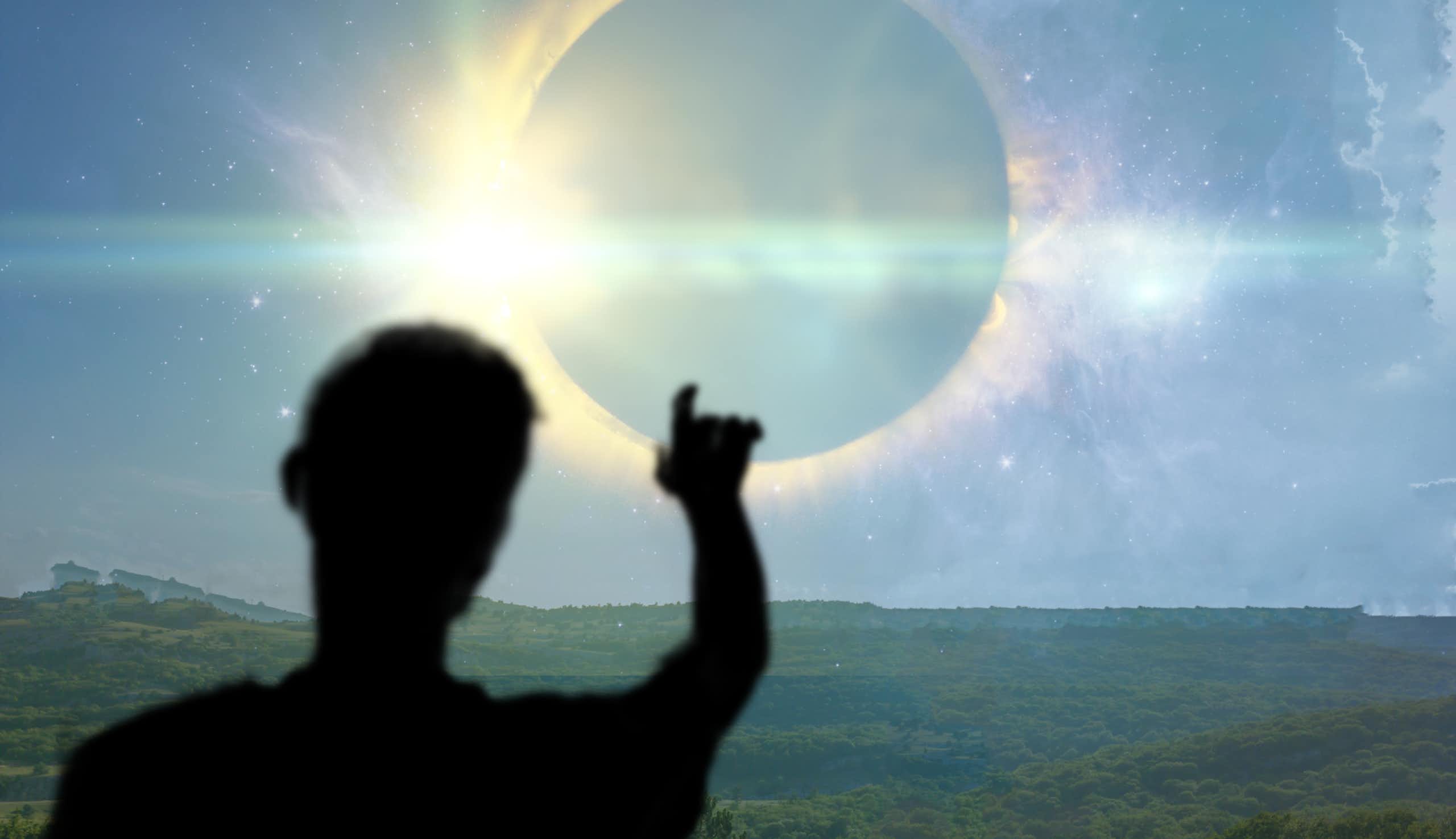 Silhouette d'un homme pointant le soleil